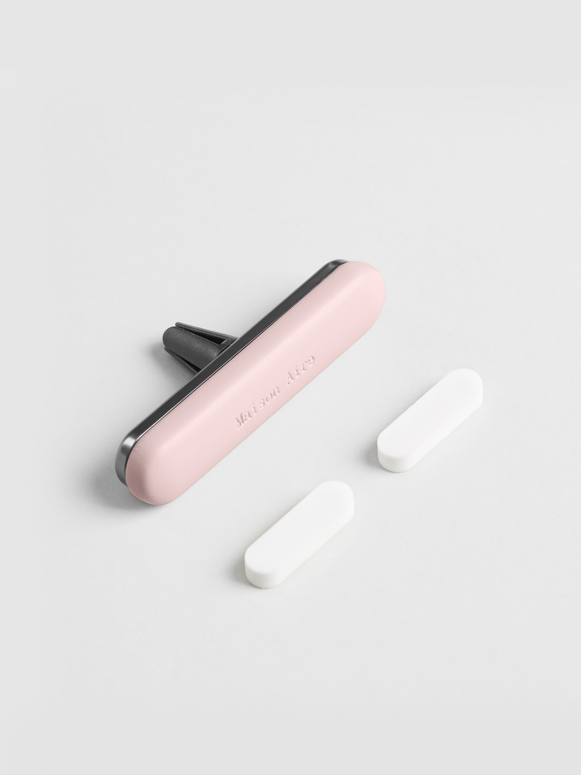 Pink leather Maison Aire car air freshener vent clip air freshener with two white scent refill disks on white background